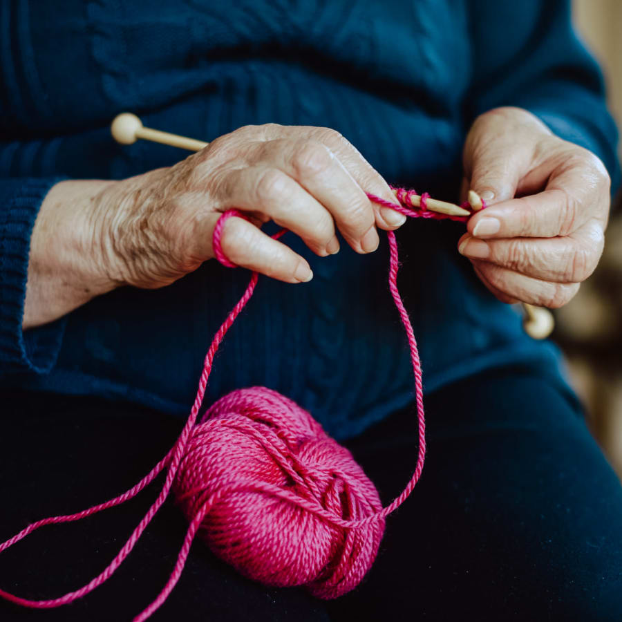 Resident knitting with pink wool at Harmony Place in Charlotte, North Carolina