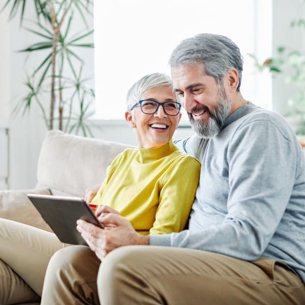 A resident couple looking at photos of Pacifica Senior Living Fresno in Fresno, California.