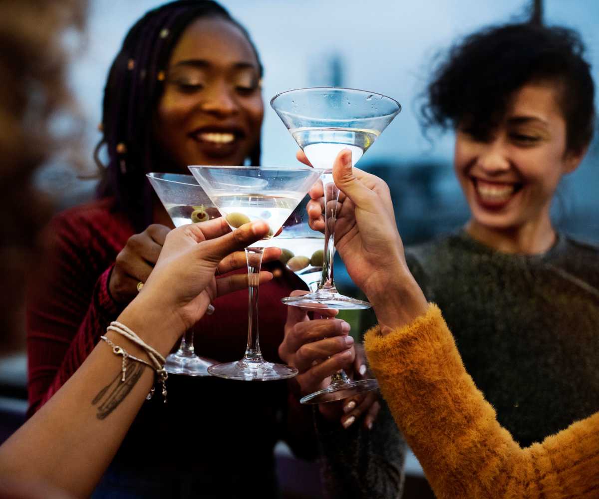 Four women joyfully toasting with martini glasses near Whispering Pines Ranch in The Woodlands, Texas