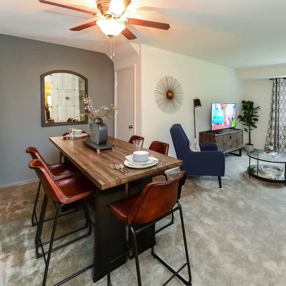 Dining area and living room in an open floor plan model home at Hill Brook Place Apartments in Bensalem, Pennsylvania