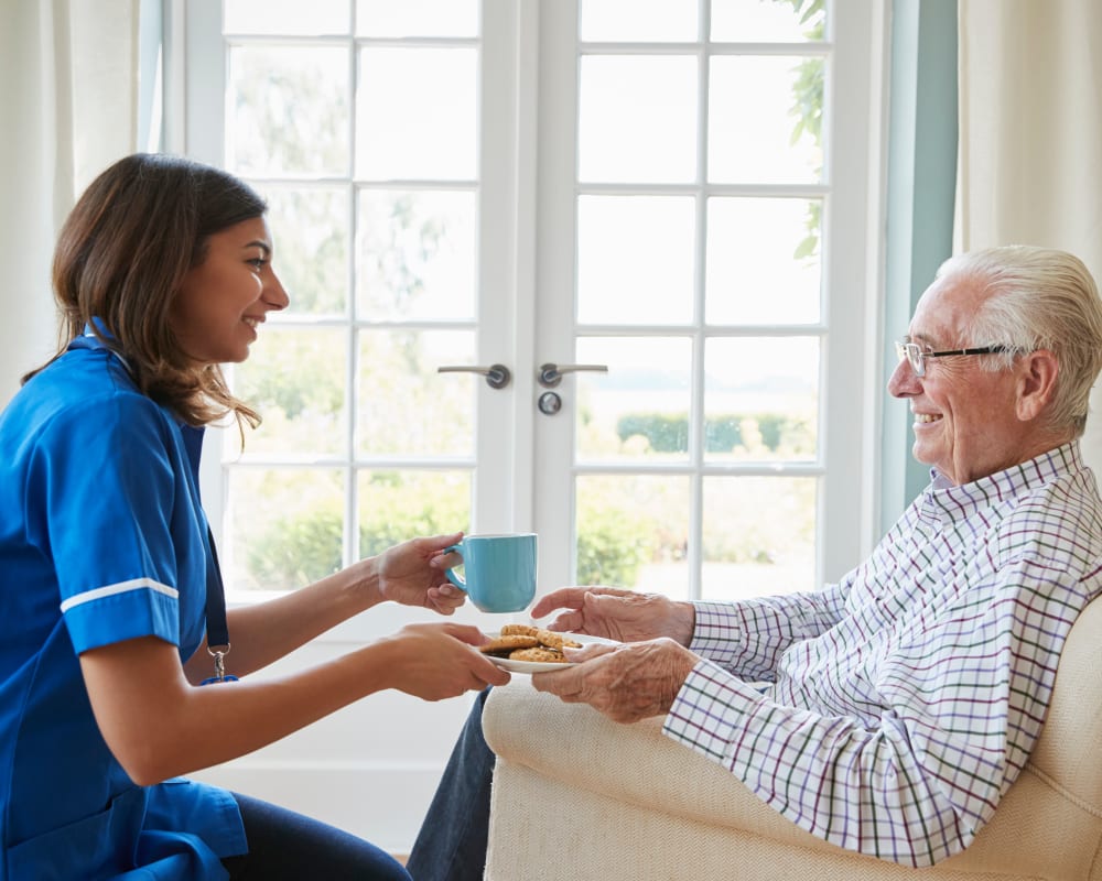 Staff member brings resident a snack in assisted living at Goodhue Living in Goodhue, Minnesota.