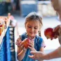 Child holding apple near WaterWalk Charlotte - Arrowood in Charlotte, North Carolina