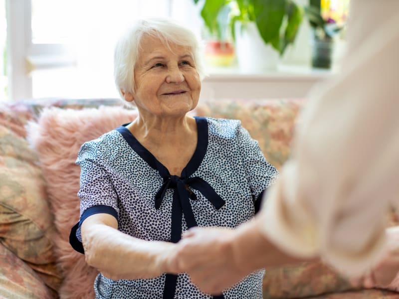 A resident holding hands with a staff member at Juniper Springs Senior Living in Redmond, Oregon. 