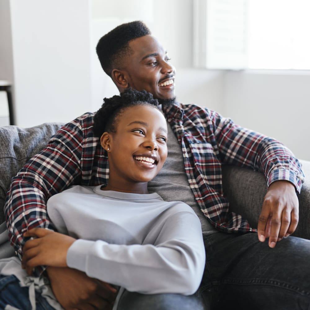 Couple relaxing on the sofa in their new home at Forge Gate Apartment Homes in Lansdale, Pennsylvania