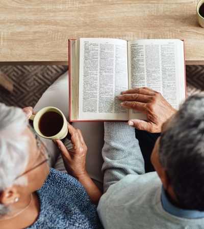 Residents reading book in a room atAthens Vista Senior Apartments in Los Angeles, California