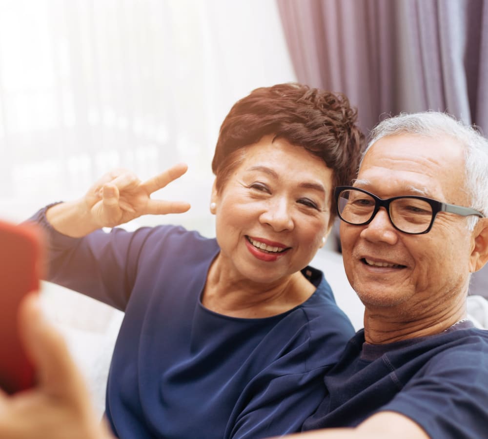 Couple taking a photo together at Fairbrooke Senior Apartments in Aberdeen, Maryland