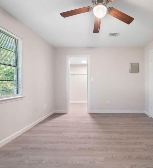 Empty room with wood flooring and a ceiling fan at 216 Broadmoor in Pensacola, Florida