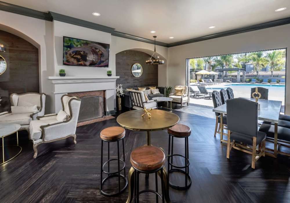 Spacious living area with tables and chairs in the clubhouse at Madrid Apartments in Mission Viejo, California