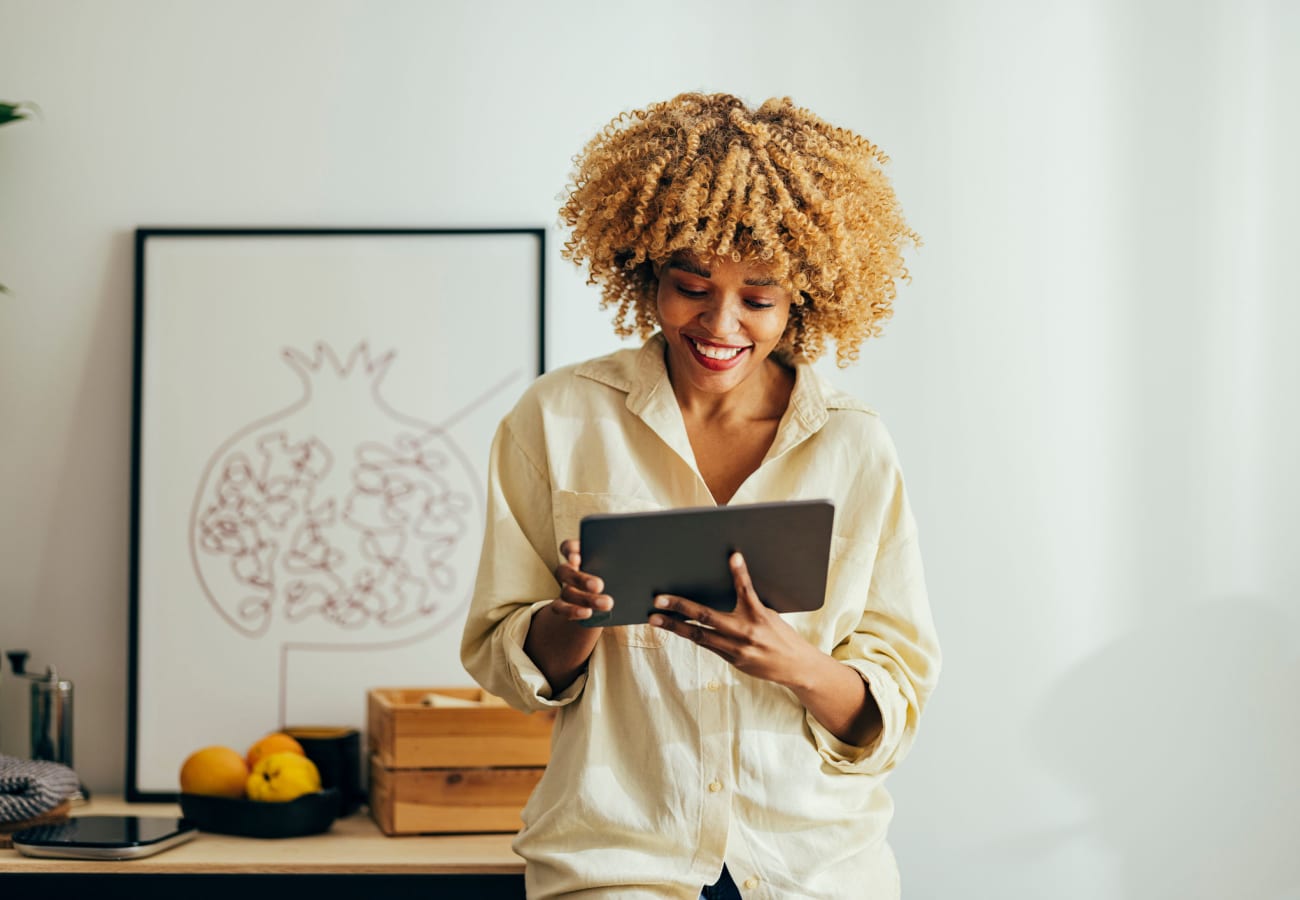 A woman smiling at a tablet at Allegiant-Carter Management in Tampa, Florida