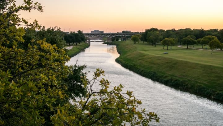 Local river and surrounding green parkland near Olympus 7th Street Station in Fort Worth, Texas