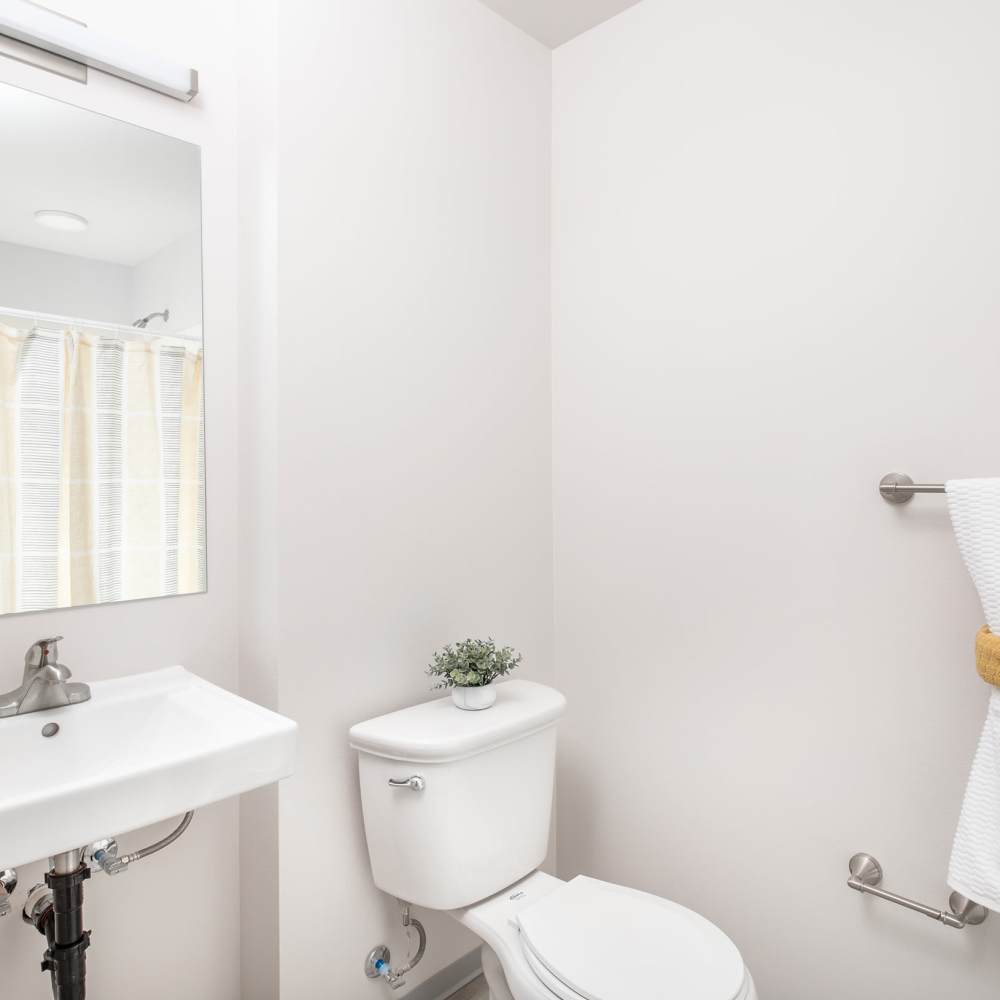A sink, toilet and towel rack in an apartment bathroom at DECRO Long Beach in Long Beach, California