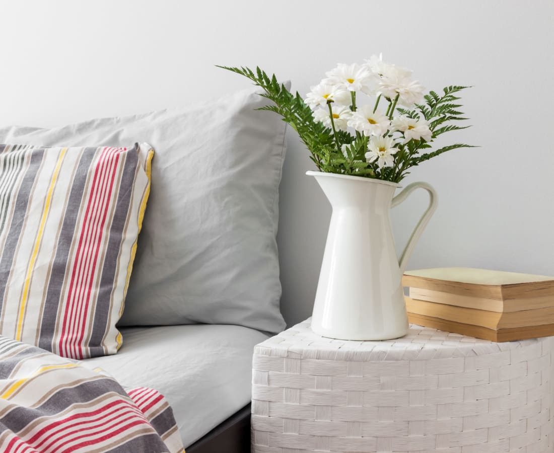 Bedside table with a potted plant and a book at Barnett Woods in Medford, Oregon