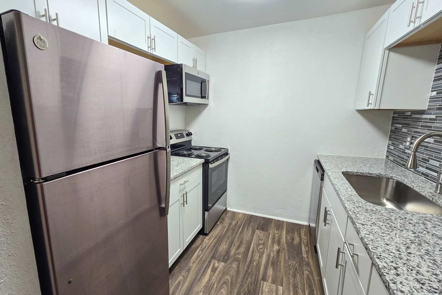 Renovated kitchen with granite countertops and stainless steel appliances