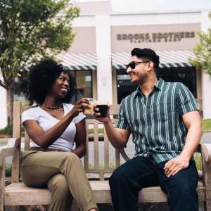 Couples having drink on a bench outside a restaurant The Maximillian at Stonefield in Charlottesville, Virginia