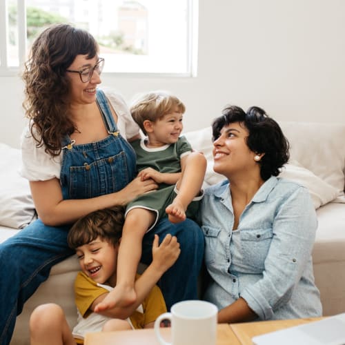 a family on the couch smiling at each other at Shadow Mountain in Twentynine Palms, California