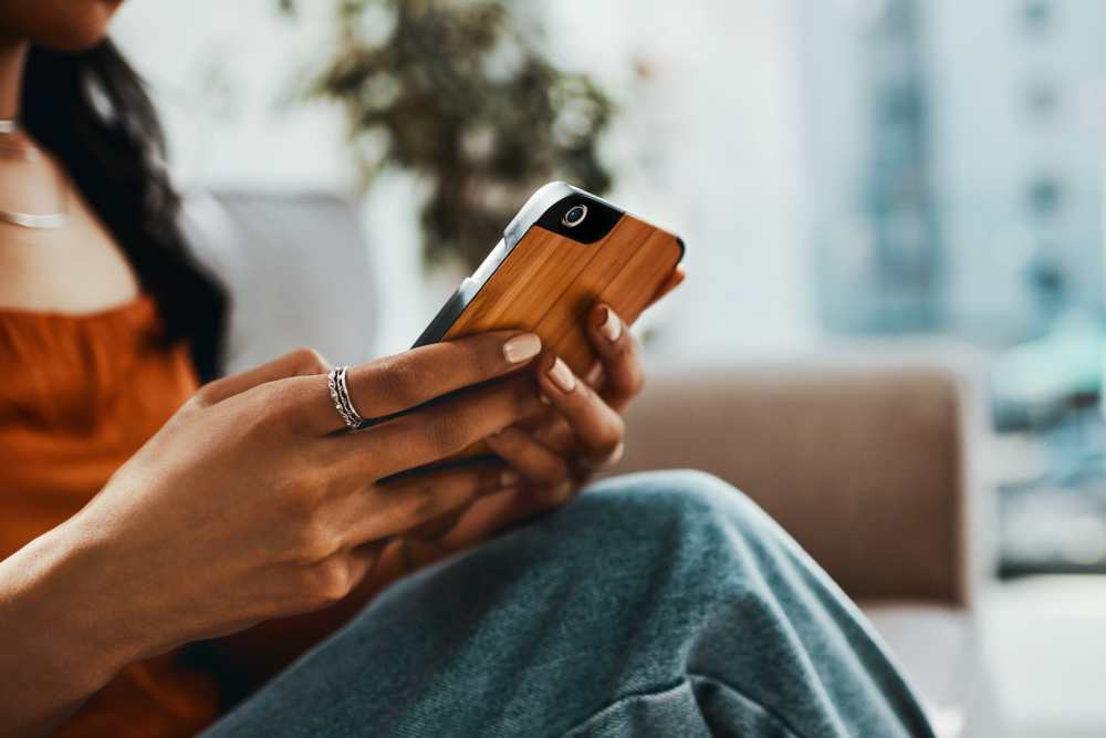 Resident woman using phone for online rental payments at Smallwood Gardens in Waldorf, Maryland