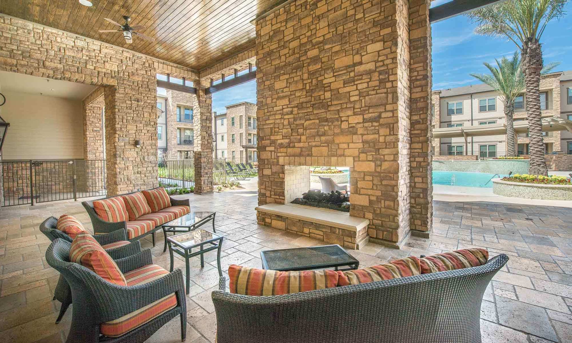 Covered seating area near the outside fireplace near The Abbey at Spring Town Center pool area 