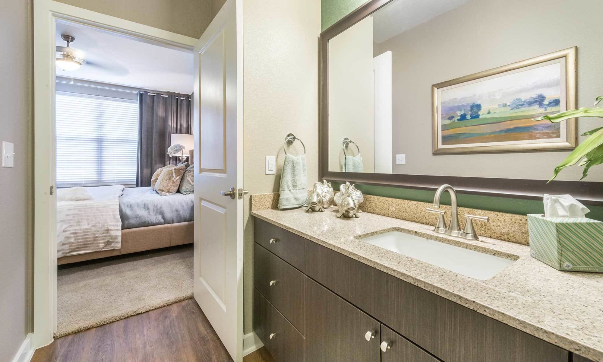 View of model apartment home's bedroom from luxurious master bath at The Abbey at Spring Town Center