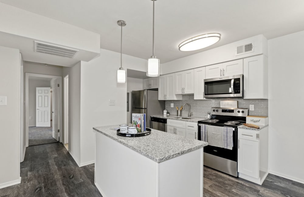 White kitchen with granite countertops and stainless steel appliances