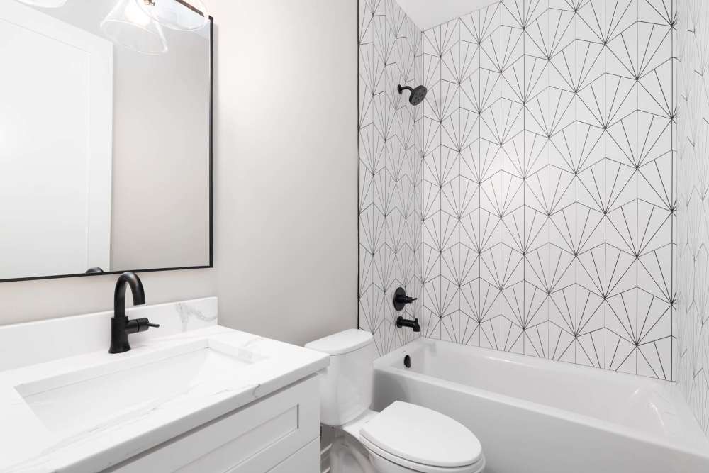 Well-lit bathroom with shower and tub at Hudson Carolina Forest in Myrtle Beach, South Carolina