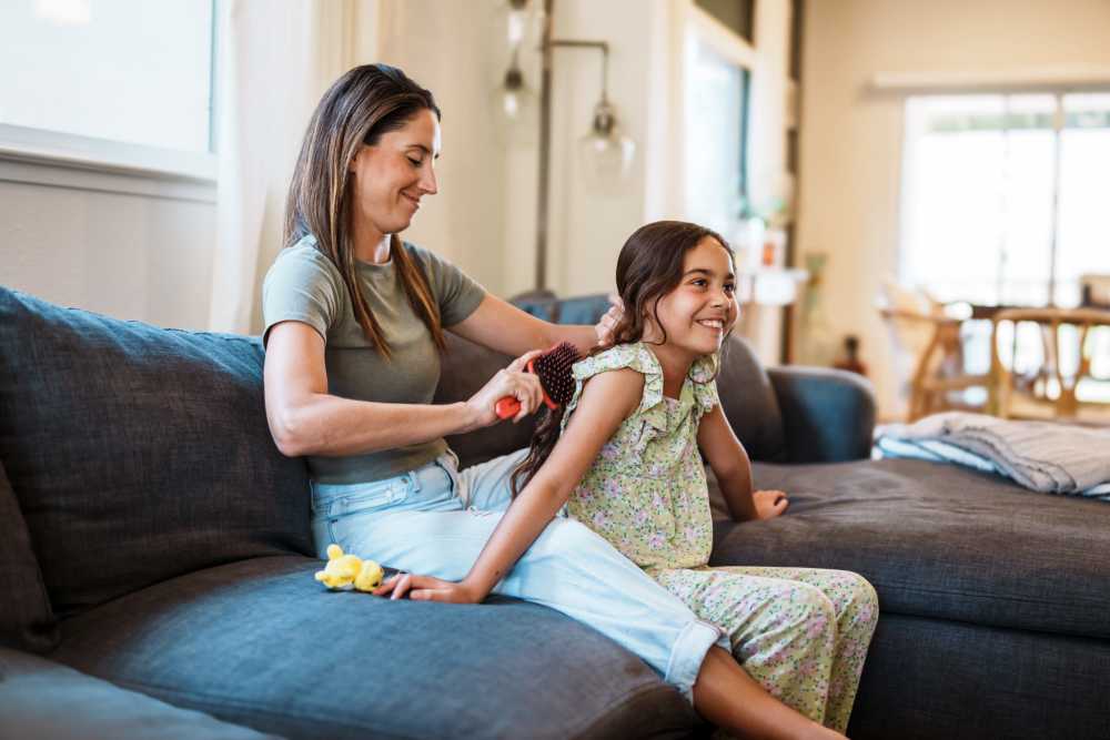 Mother combing her daughter hair at Fall Creek View Apartments in Indianapolis, Indiana