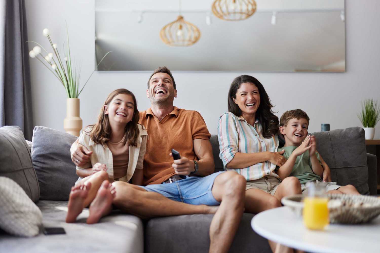 A family happily watching tv at Village Apartments in Bellaire, Michigan