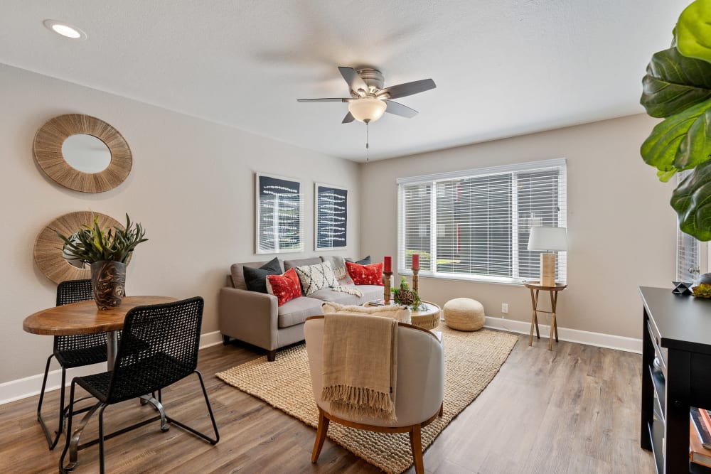 Model living room with wood-style flooring at Pinebrook Apartment Homes in Fremont, California