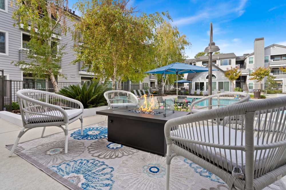 Comfortable outdoor seating with fire pits at The Reserve at Capital Center Apartment Homes in Rancho Cordova, California