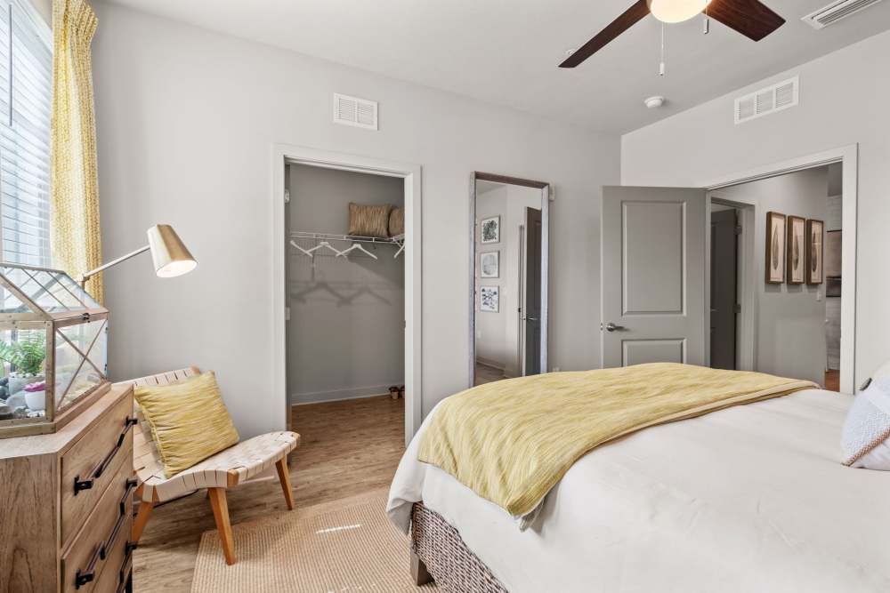 Bedroom with wood style flooring and walk-in closet at Pier Park Crossings in PCB, FL.