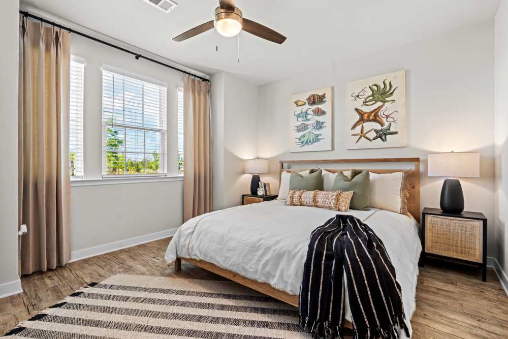 Guest bedroom at Mexico Beach Crossings Apartments with large window, bed, and nightstands.