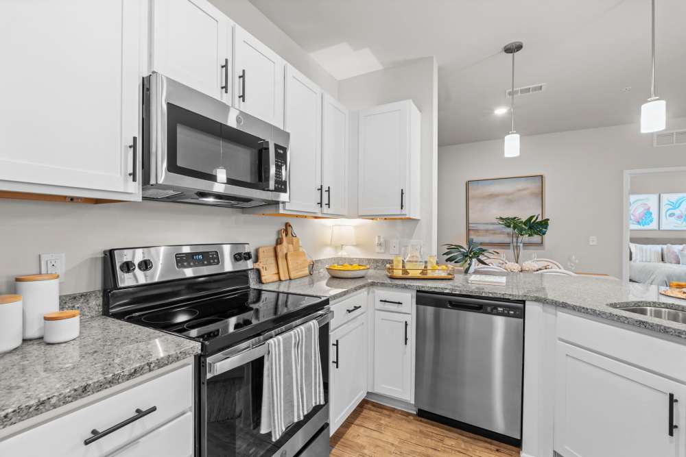 Two bedroom kitchen with white cabinets, granite counters, and stainless steel appliances in Mexico Beach, FL.