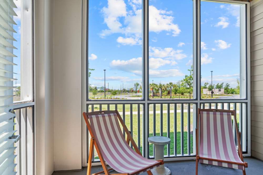 Screened in patio with two chairs and table at Mexico Beach Crossings Apartments.