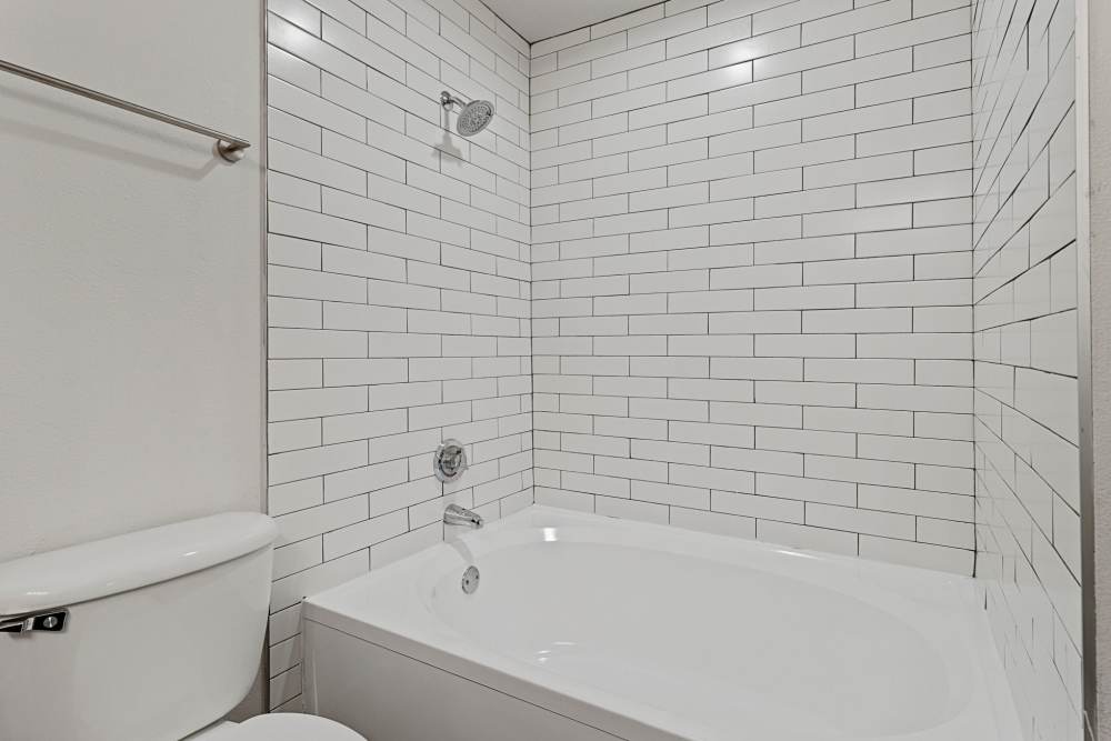 Bathroom with standard tub and tiles around at Sullivan in Austin, Texas