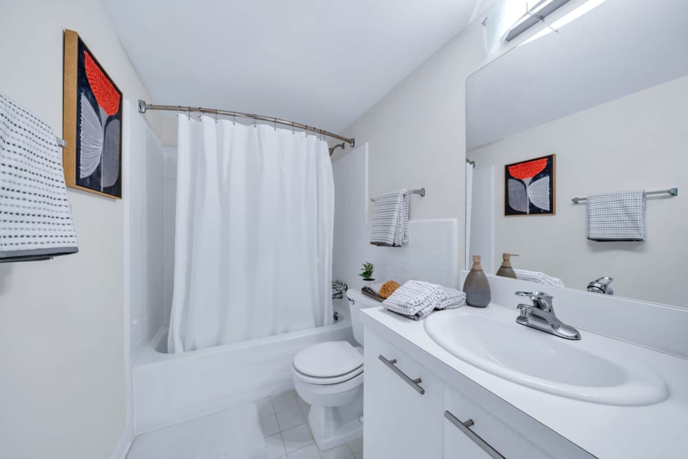 Bathroom with tiled shower/tub combination and white cabinetry at Muirwood in Farmington Hills, Michigan