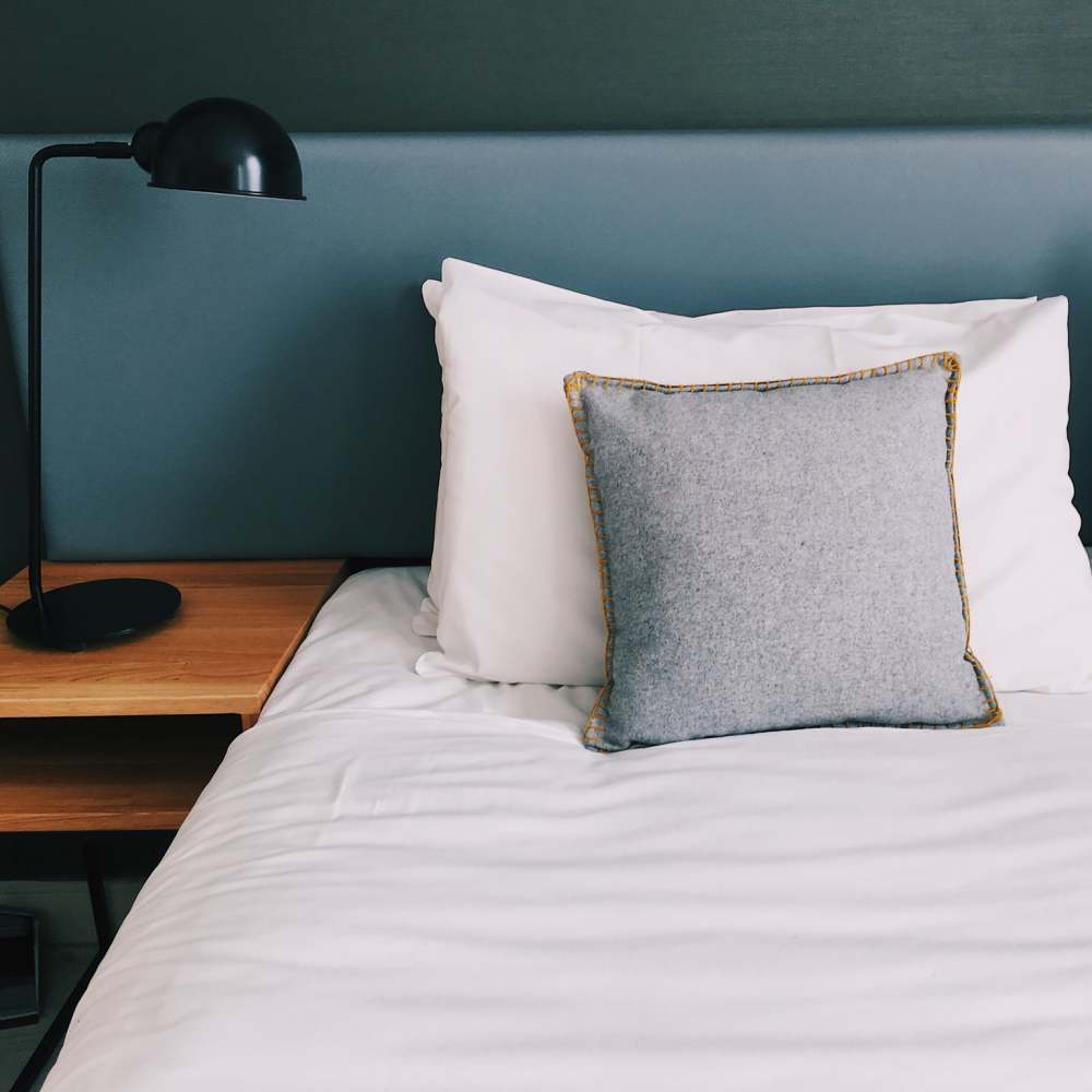 Modern-style bed and nightstand at Coral Wood Court in Reseda, California