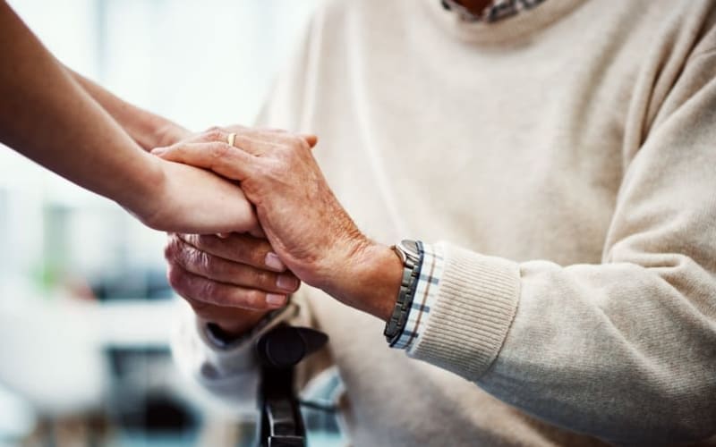 Friendly staff member lending a helping hand to resident at Grand Villa of New Port Richey in New Port Richey, Florida