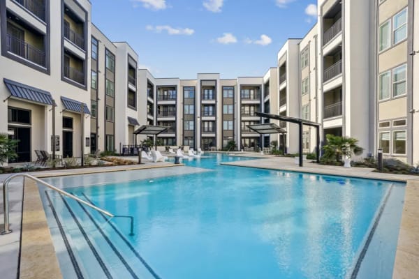 Resort-style pool at the active adult community with views of the surrounding apartment buildings in the background.