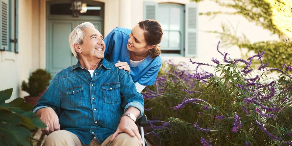 A staff member helping a resident in a wheelchair at Careage at Home in Bellevue, Washington. 