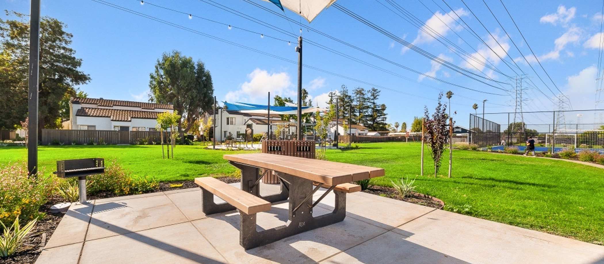 A picnic table and grill set up in a backyard at Mariposa Fremont in Fremont, California.