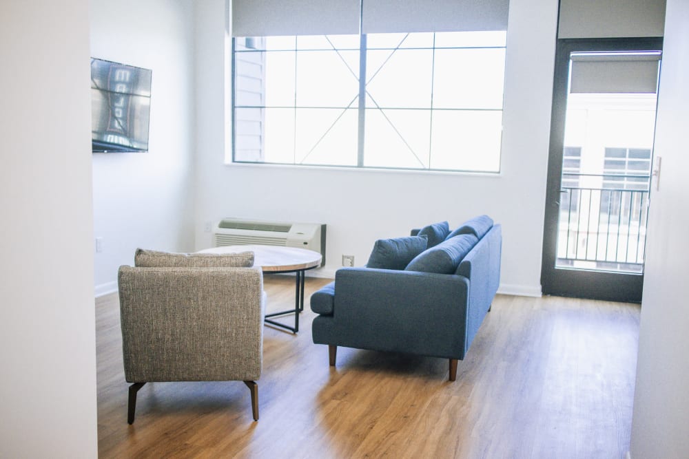 Spacious living room with wood-style flooring at University Lofts at Russellville, Russellville, Arkansas