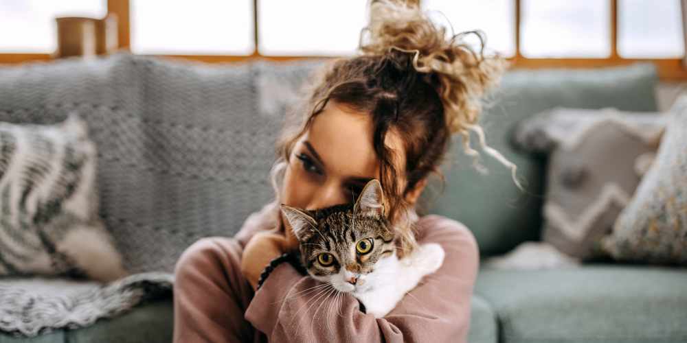 Resident playing with her cat in her pet-friendly apartment at Grande Pointe in Orlando, Florida