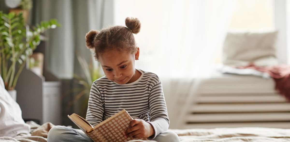 A young girl reads a book in her bedroom at Elevations One, Woodbridge, Virginia
