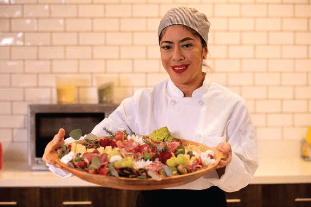 Chef presenting a platter of fresh fruits at Clearwater at The Heights in Houston, Texas