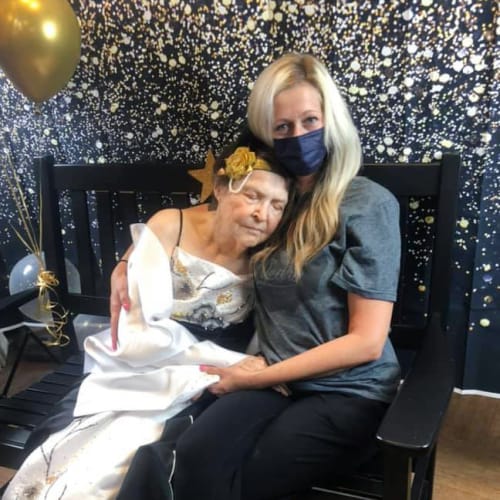 Resident snuggling with a caretaker at Oxford Glen Memory Care at Owasso in Owasso, Oklahoma