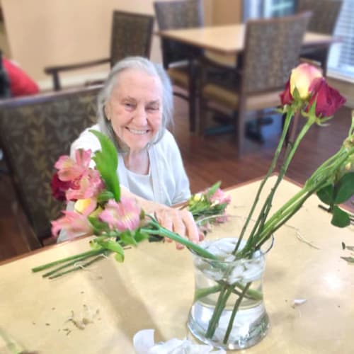 Resident with flowers at Oxford Glen Memory Care at Grand Prairie in Grand Prairie, Texas