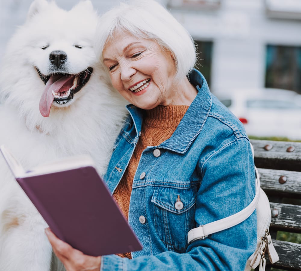 Resident and her dog reading at Sage Glendale in Glendale, California.