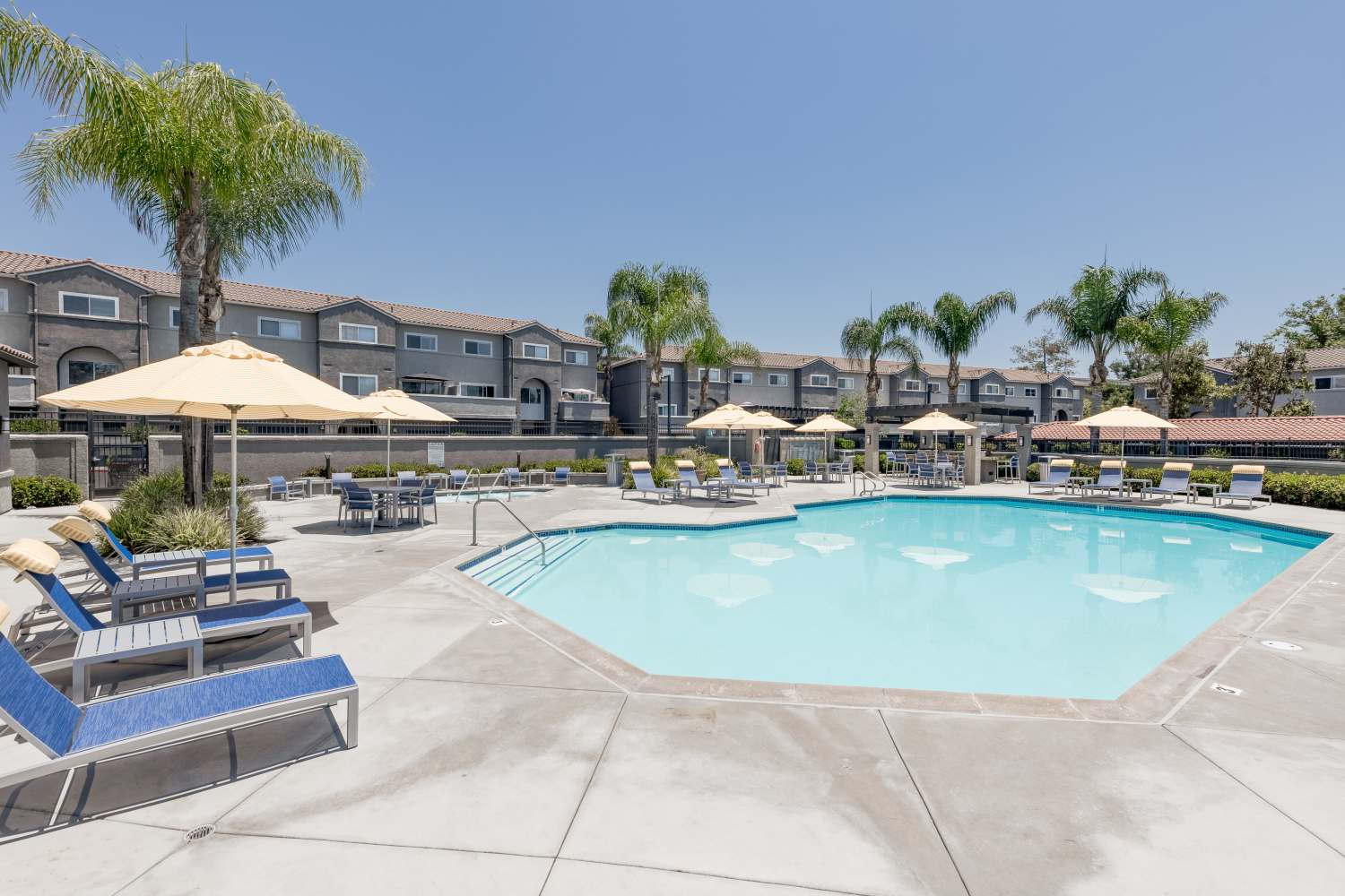 Sun loungers by the pool at Madrid Apartments in Mission Viejo, California