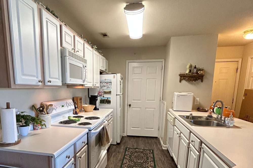 Apartment kitchen with white appliances and cabinets at The Landing at Fayetteville in Fayetteville, Arkansas