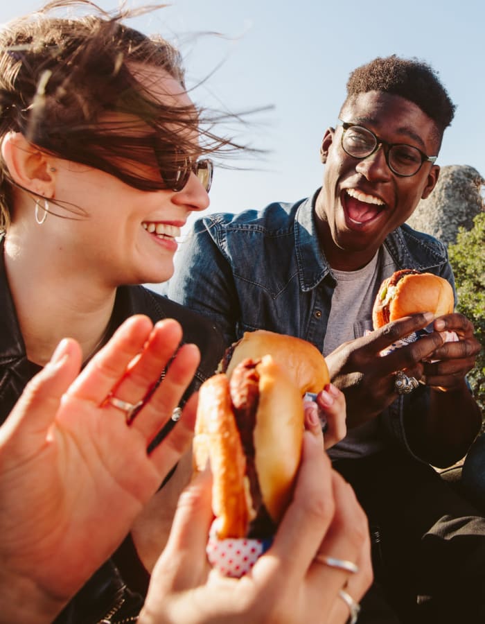 Student friends enjoying delicious hamburgers outside on a beautiful day near University Village in Greensboro, North Carolina