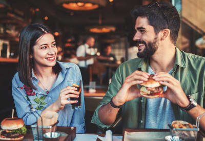 Resident couple enjoying a tasty burger at their favorite spot near Signal Pointe Apartment Homes in Winter Park, Florida